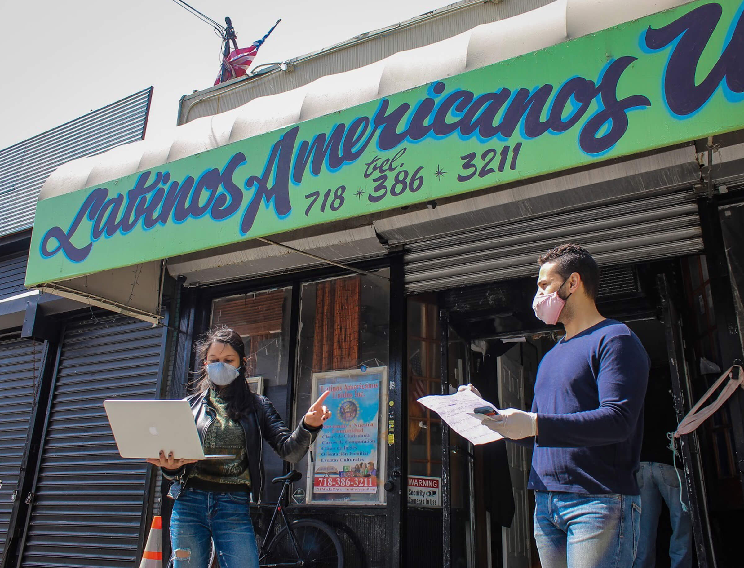Two volunteers reading instructions outside Latinas Americanas